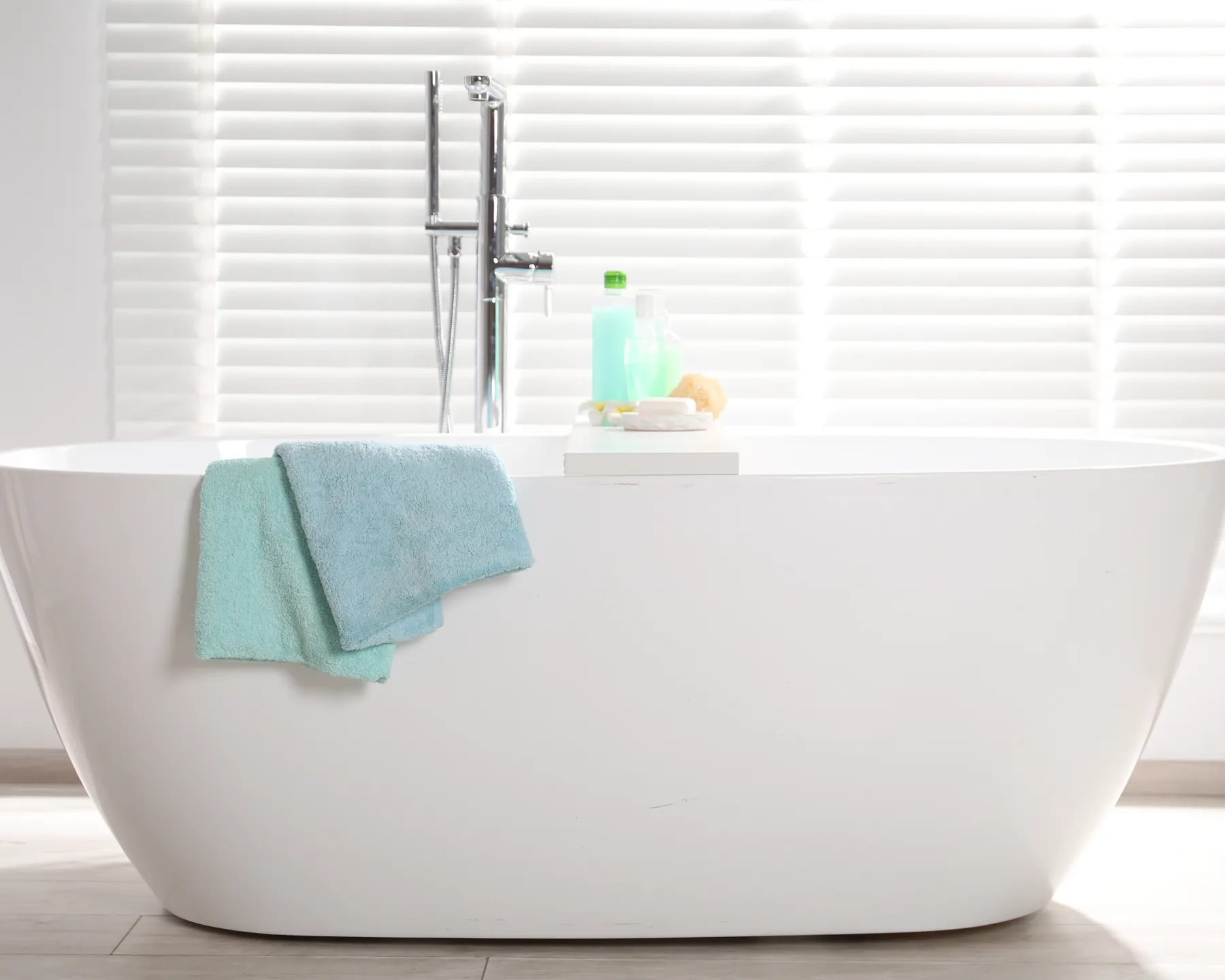 A bright bathroom with a freestanding tub and spa accessories, used as a temporary services hero image.