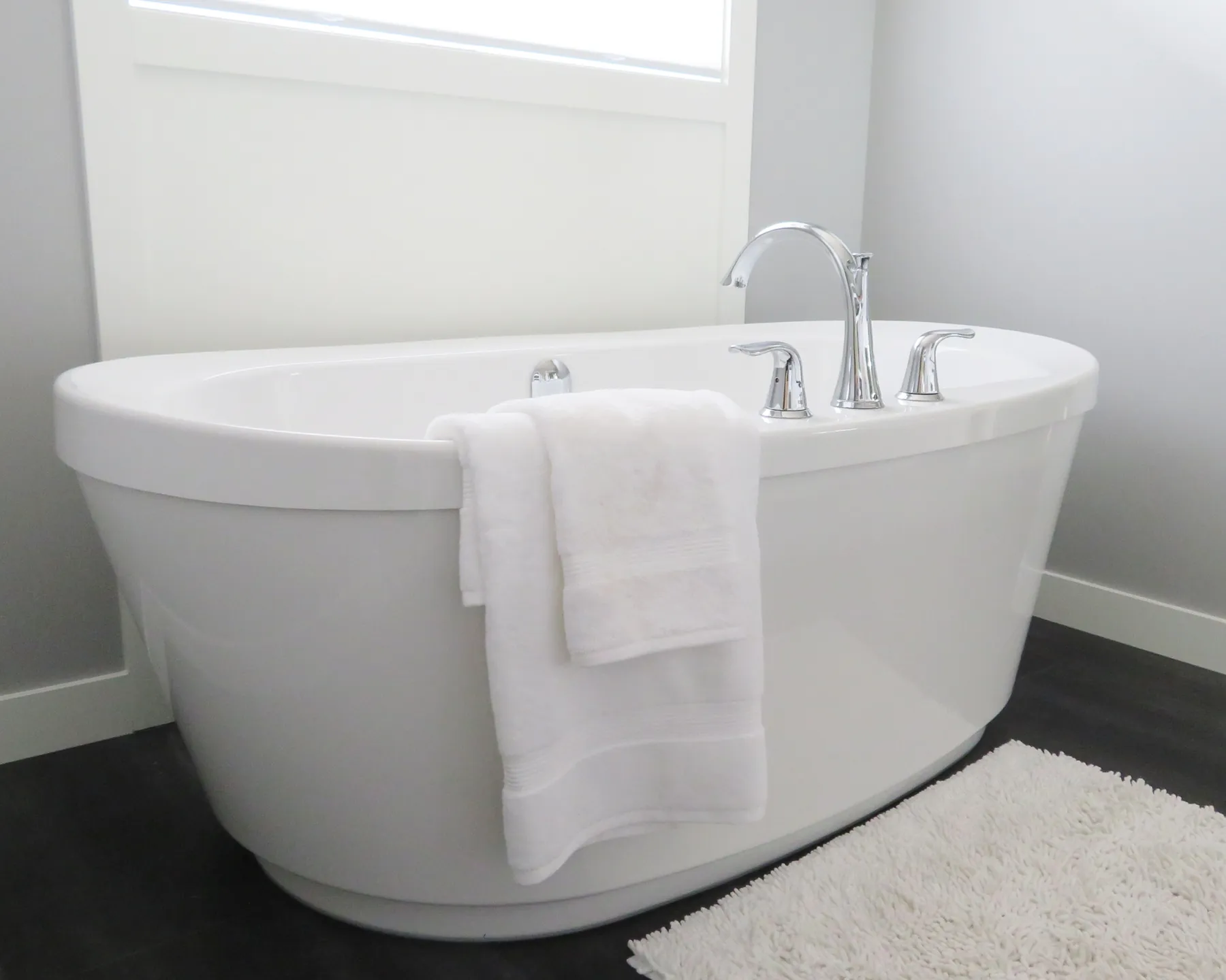 Placeholder image of a white freestanding bathtub with a folded towel.